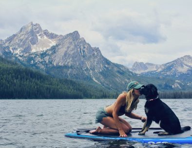 Girl with dog paddle boarding on Lake Tahoe