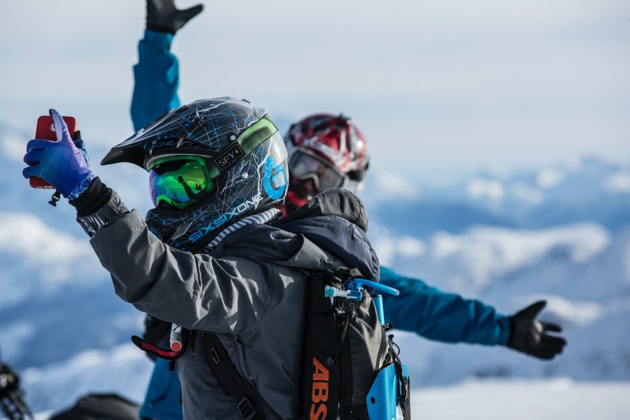 person holds red smartphone taking selfie at daytime